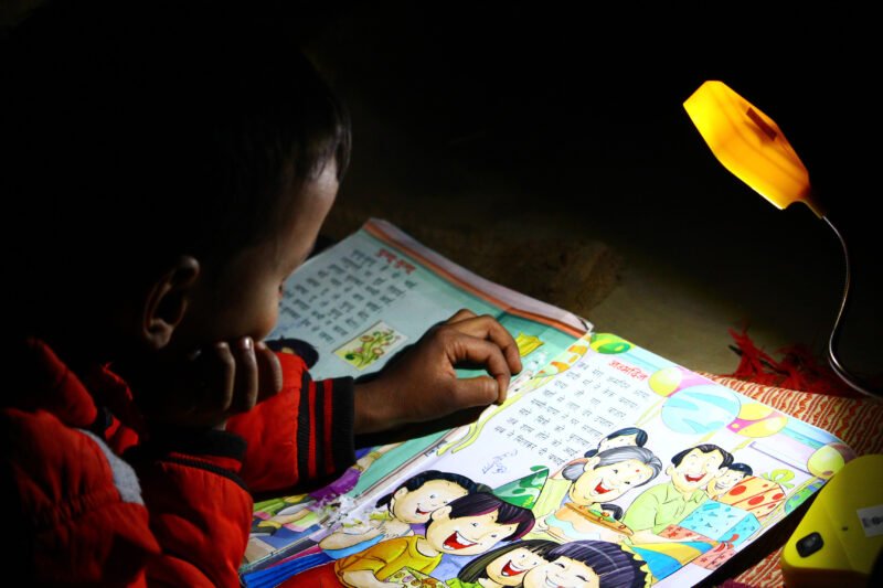 Printing - student studying a book with solar lamp